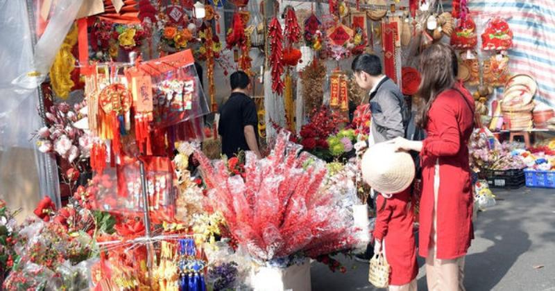 Một khu chợ hoa Tết truyền thống với nhiều gian hàng trưng bày và bán hoa nhất chi mai trắng